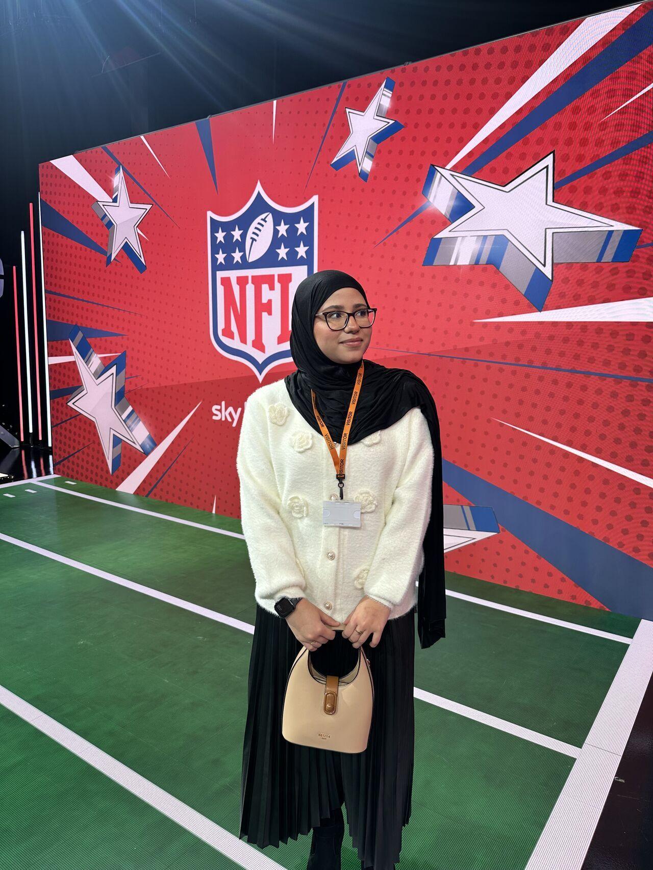 Hibatollah, a young hijabi woman and member of the NTG community, stands in the Sky Sports Studios looking awestruck.