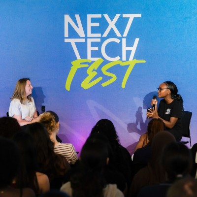 A young woman interviews a female Chief Technology Officer on stage at Next Tech Fest