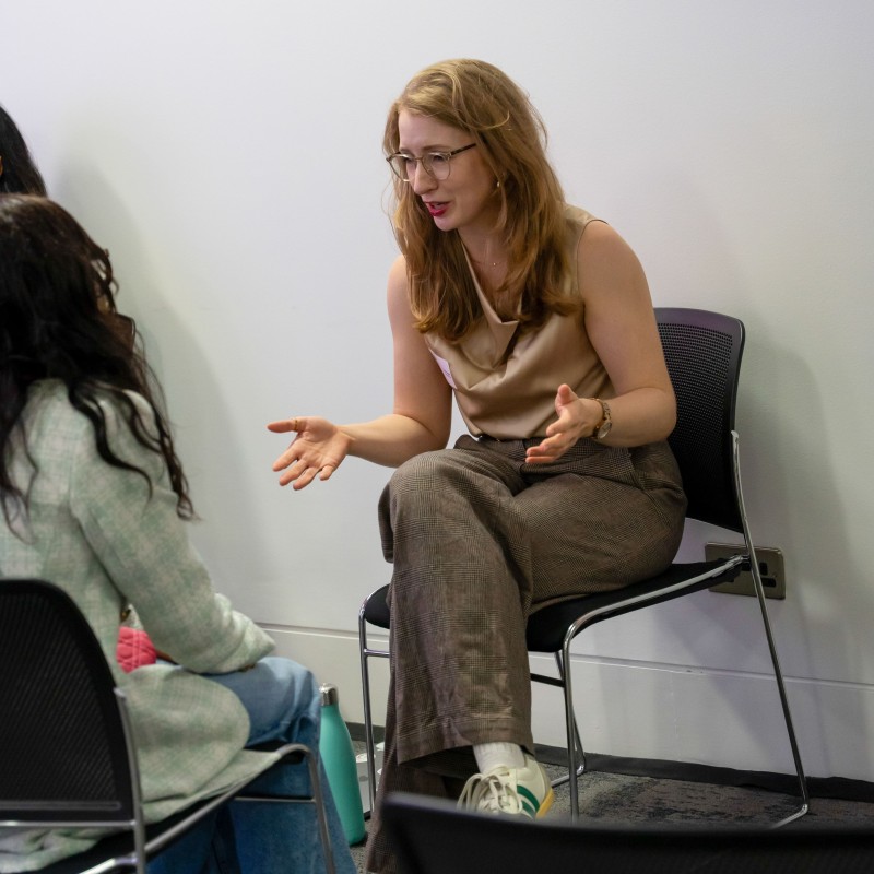 Chloe from ControlPlane speaking animatedly to a young woman during a speed mentoring session at Next Tech Fest 2025.