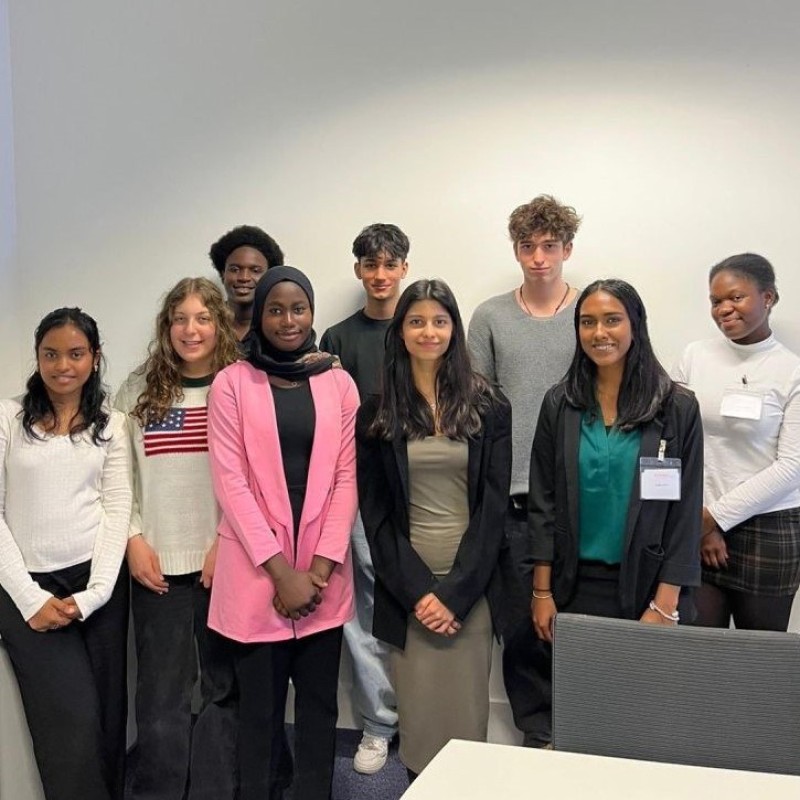 A group of young women and men smiling at the camera during their work experience with Atos.