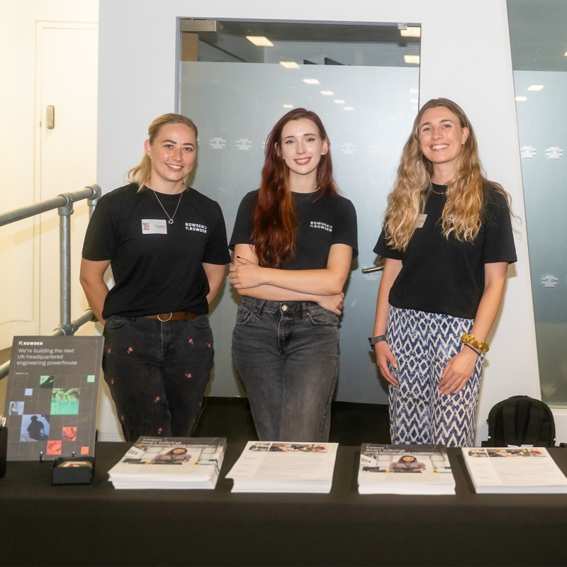 Three young women in Rowden t-shirts representing their team at an exhibition stand at Next Tech Fest 2025