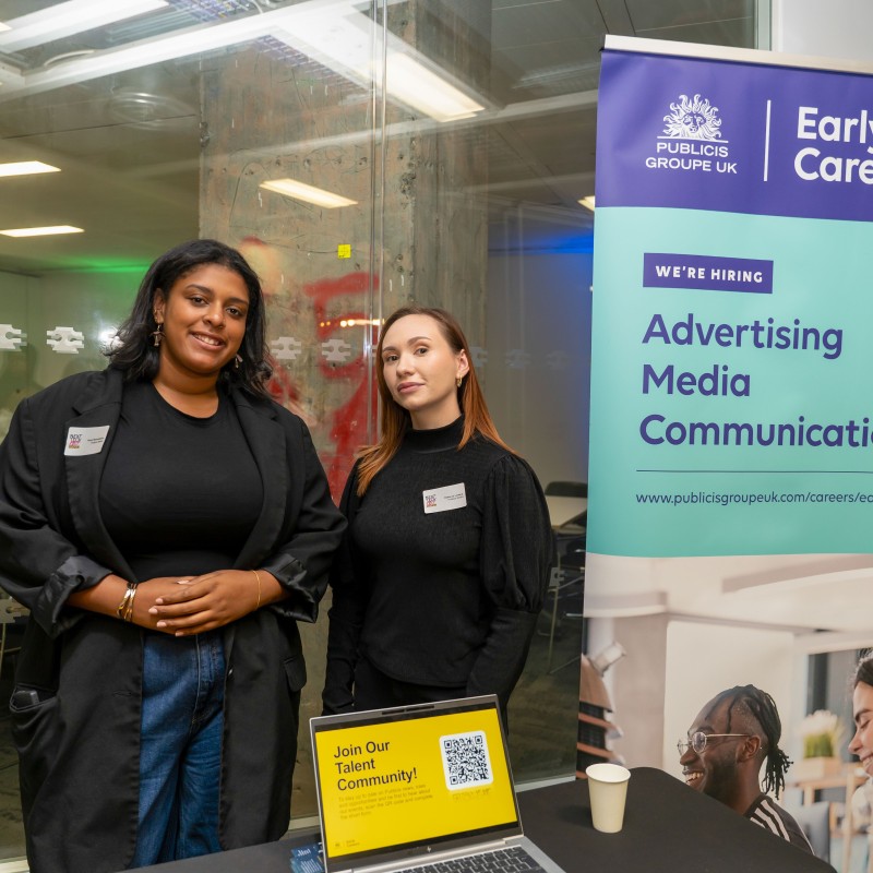 Two women from Publicis Media standing at an exhibition stand at Next Tech Fest 2025, next to an 'Early Careers' banner.
